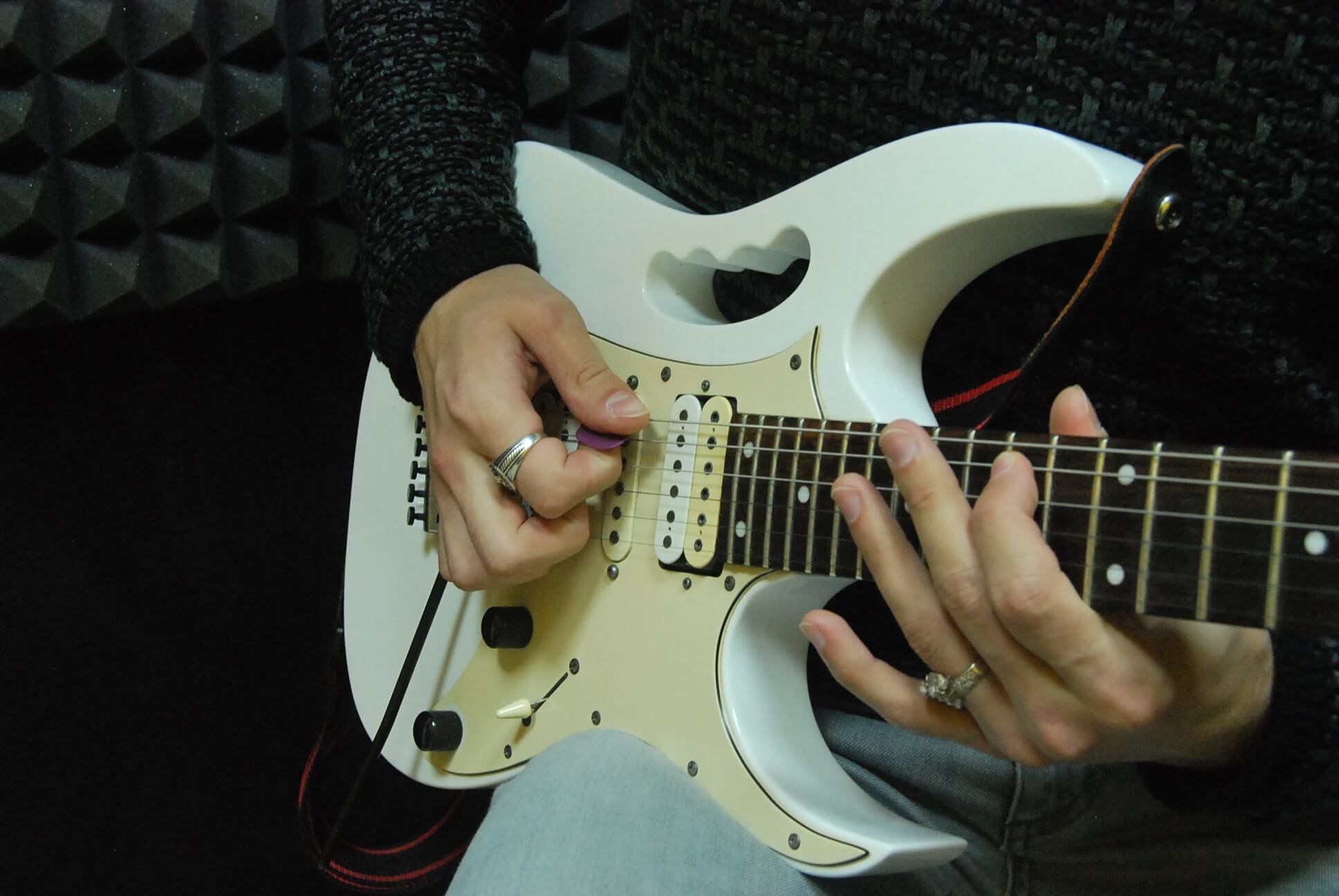 Ребенок учится инрать на белой электро гитаре 