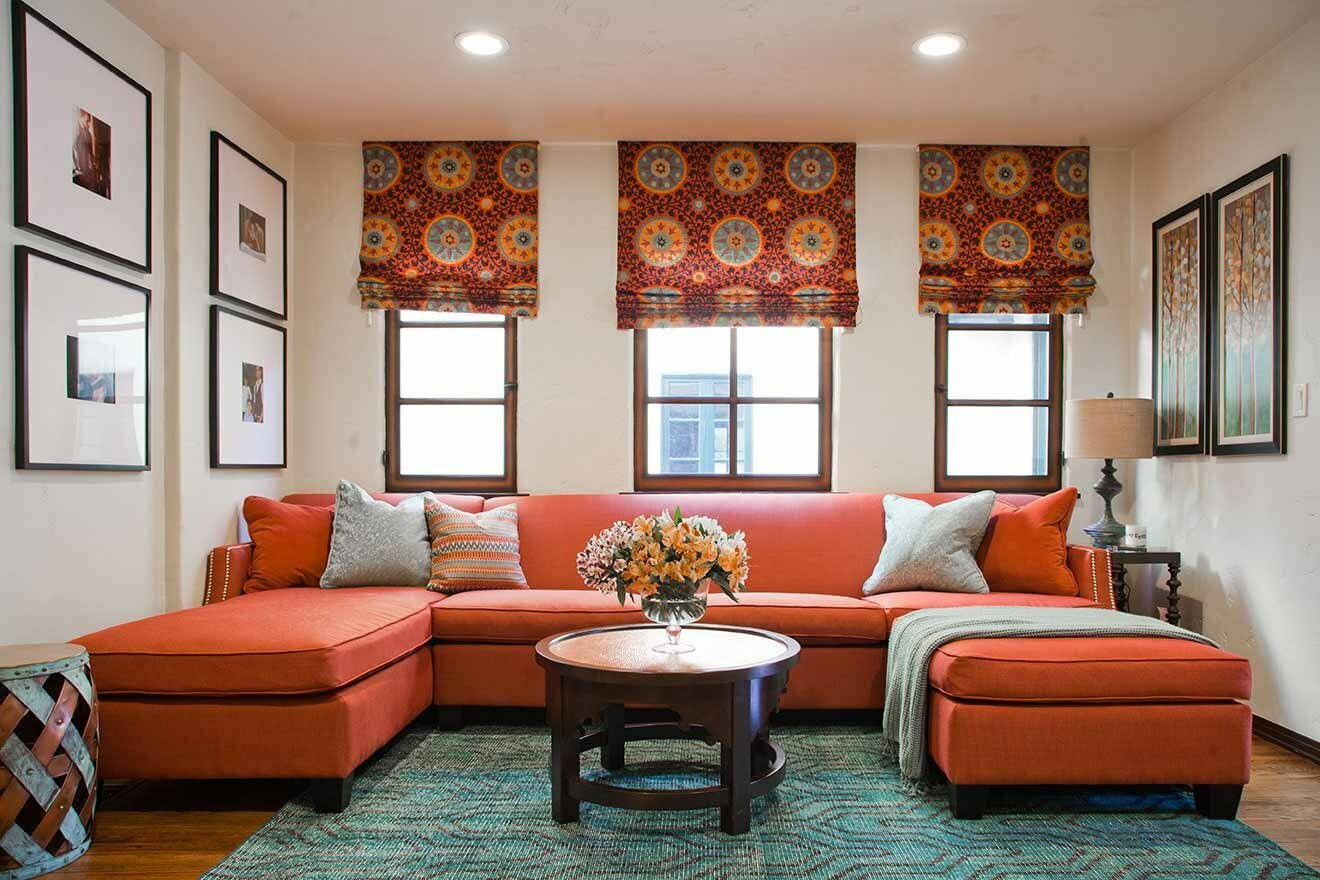 серый диван с оранжевыми подушками