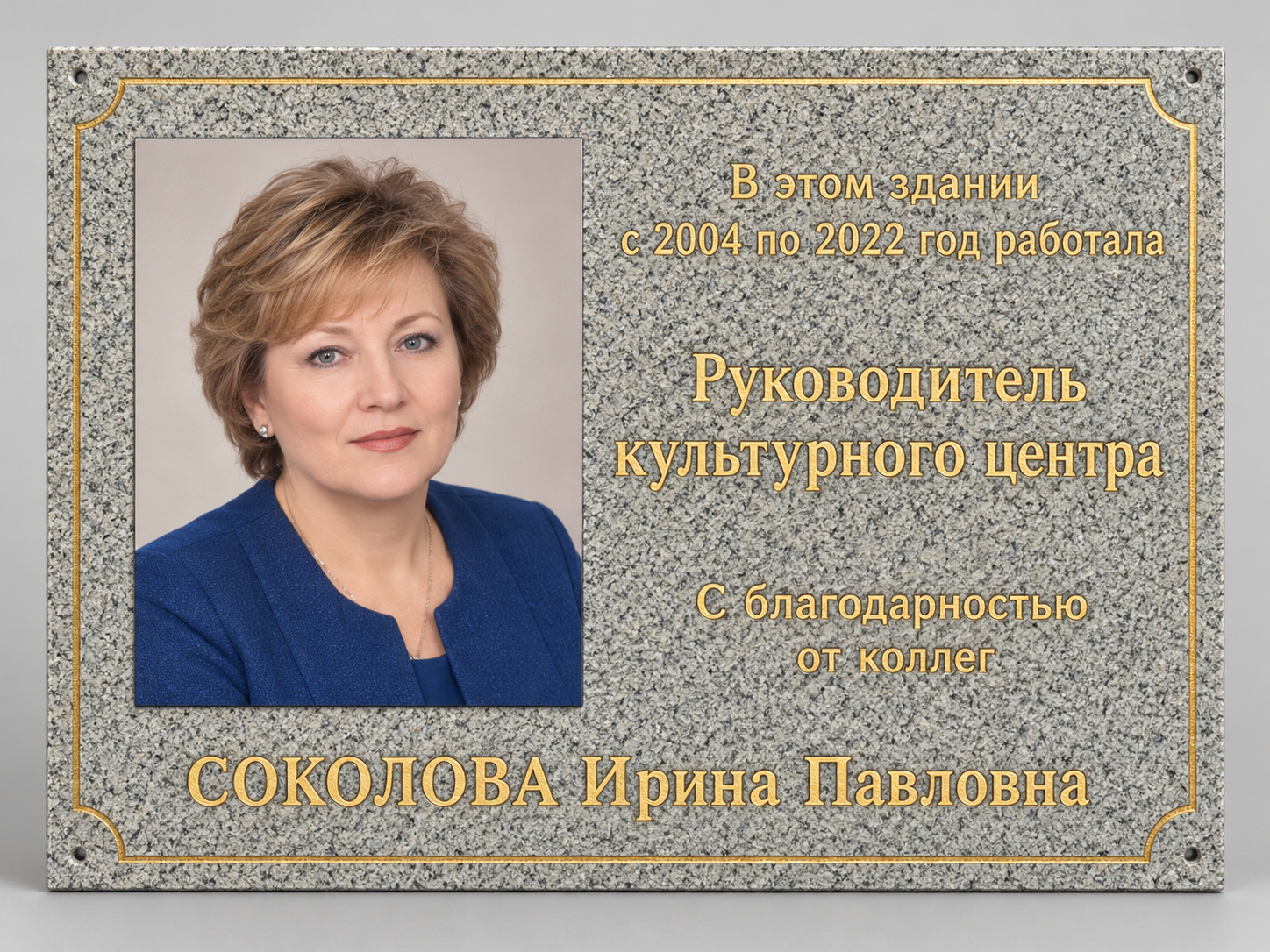 Светлая гранитная доска с цветной фотографией, золотистой рамкой и надписью. Портрет и данные изменены.
