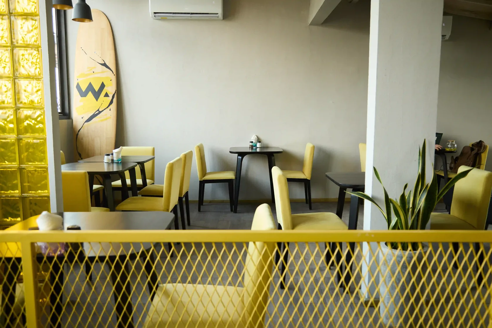 The bright and casual interior of WORD Hummus Bar in Canggu, featuring vibrant yellow chairs and relaxed seating, making it a popular 24/7 spot for plant-based options and vegan-friendly Russian food in Bali.