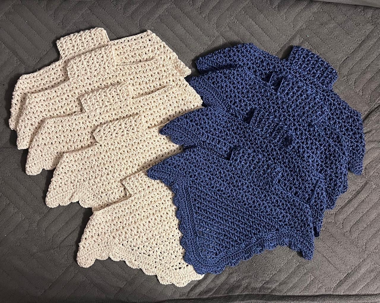 Knitted ear bonnet blanks in cream and dark navy.