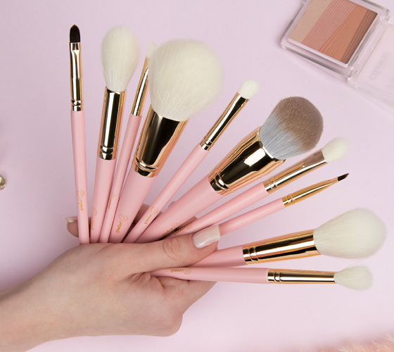 кисти с розовыми ручками в руке