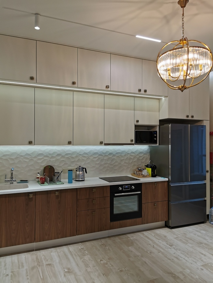 современный светлый кухонный гарнитур с антресолями и рельефным белым фартуком, магнитным шинопроводом