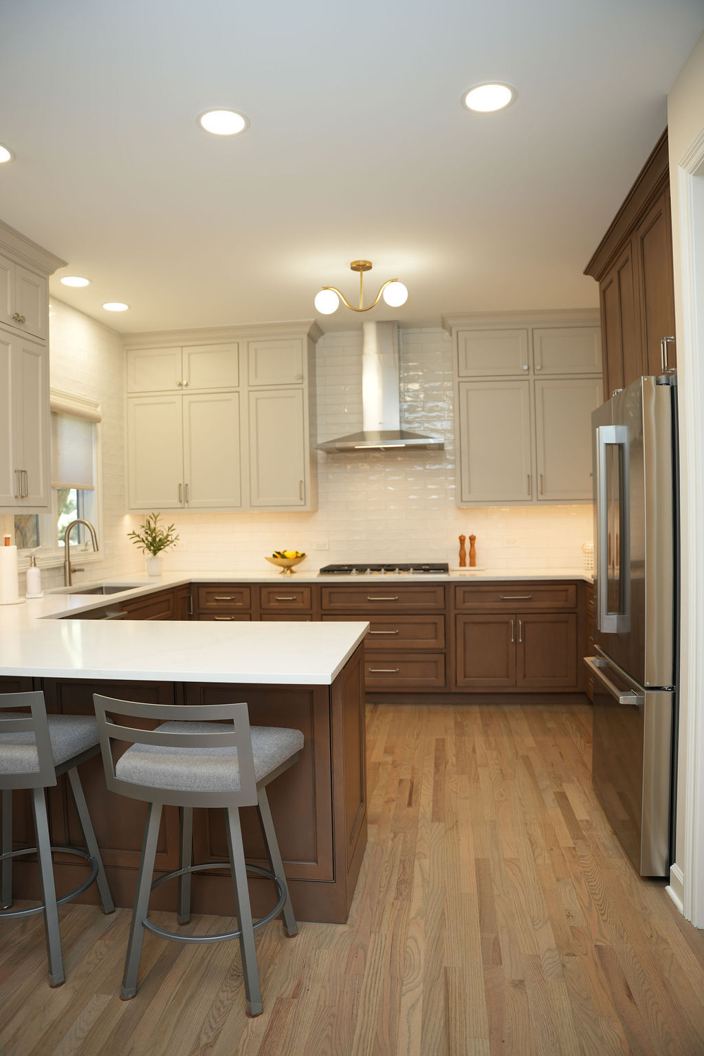 Remodeled kitchen with white and dark wood cabinetry, large island, and stainless steel appliances