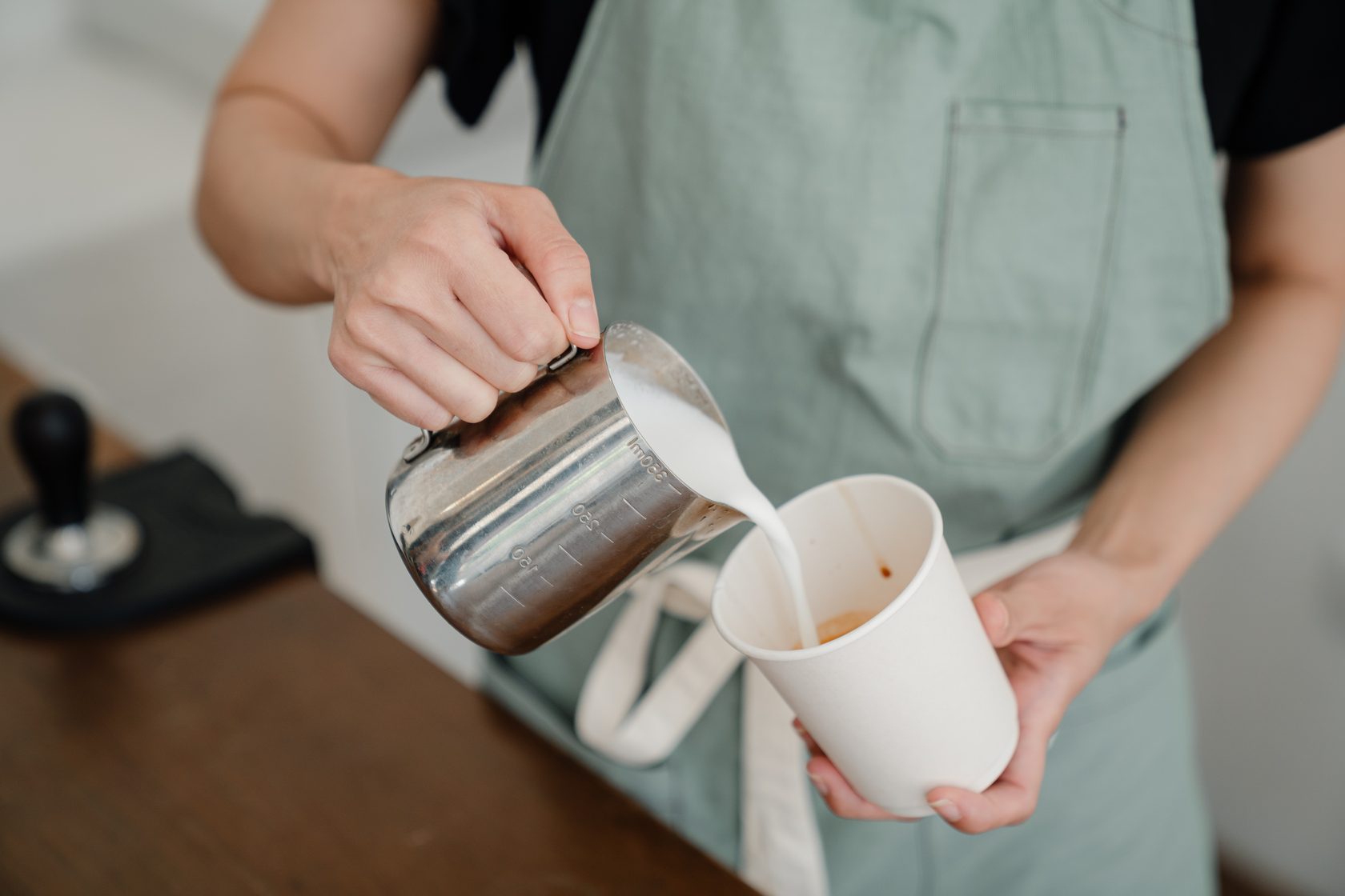 Doing coffee. Девушка держит в руке Milk Frother. Barista doing Milk.