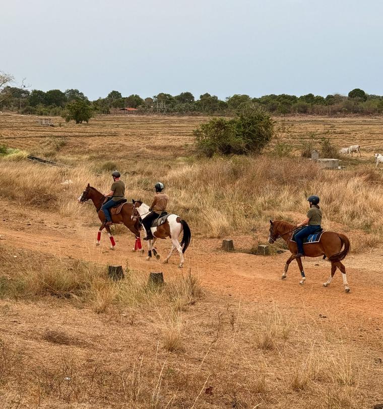 Riders on horseback moving through rural dry-zone landscape in Sri Lanka reflecting experience-led tourism at VONFIDEL RANCH.