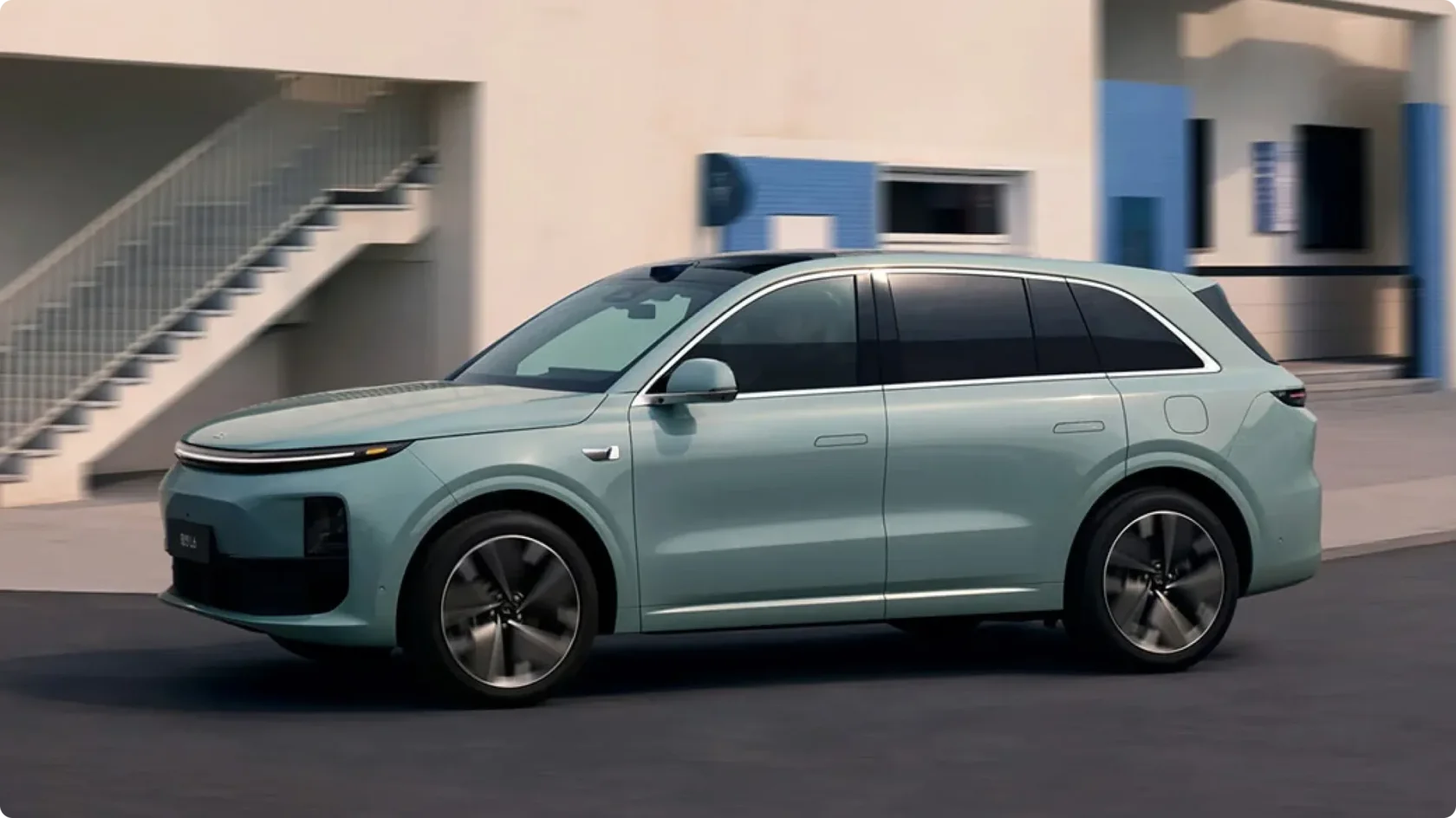 Гибридный кроссовер Li Auto L6 в новом цвете Azure (небесно-голубой) в движении, вид сбоку: светодиодная полоса, лидар на крыше и новые аэродинамические диски.