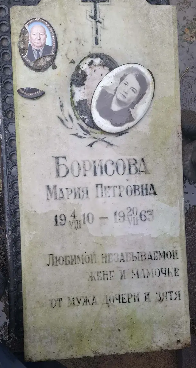 Светлая стела до обновления: старые надписи, овальные фотомедальоны и следы загрязнения поверхности.