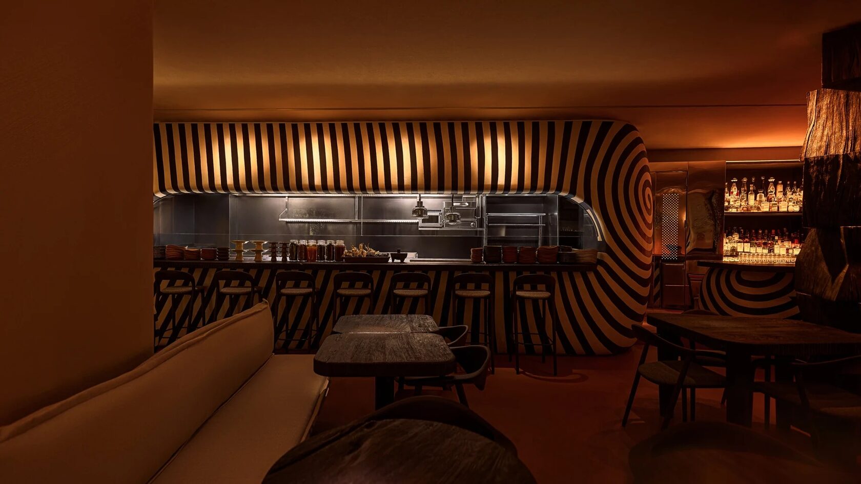 Tables and the sculptural wooden bar inside Sobremesa in Dubai