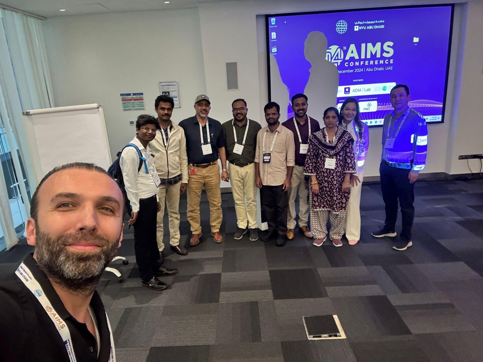 A group of people standing in a room
Description automatically generated