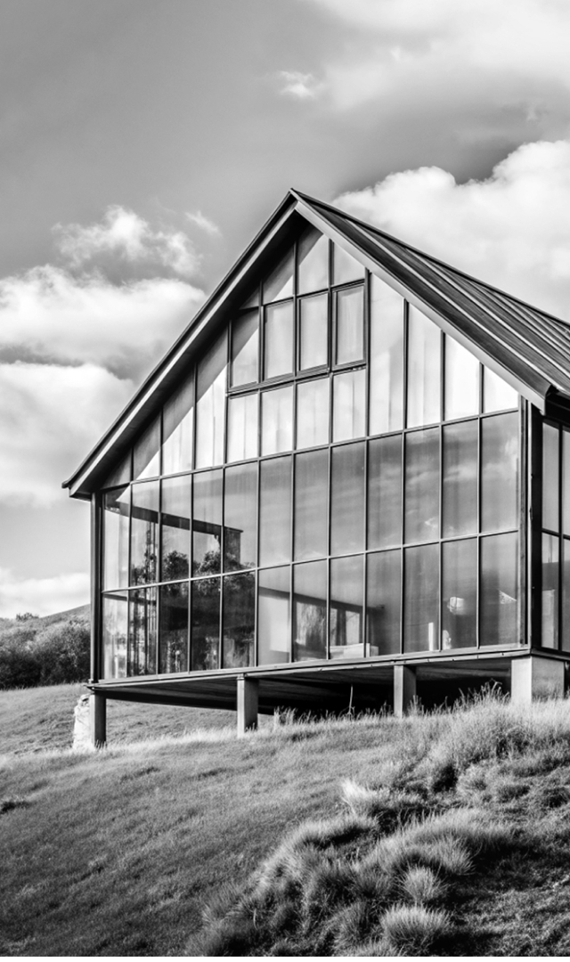 Black and white photo: barn house stands on a hill