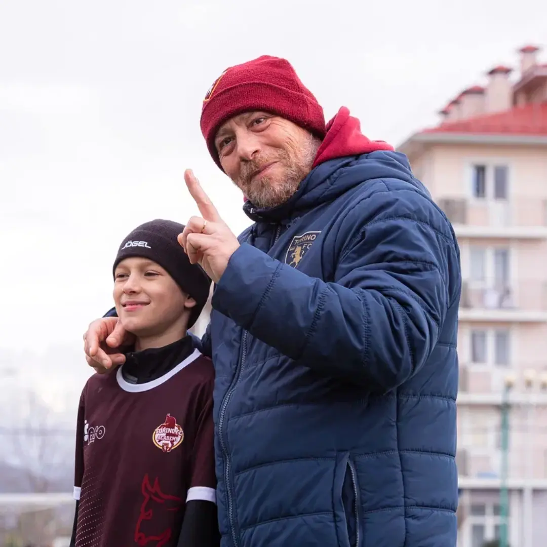 Тренер и юный футболист после тренировочного занятия