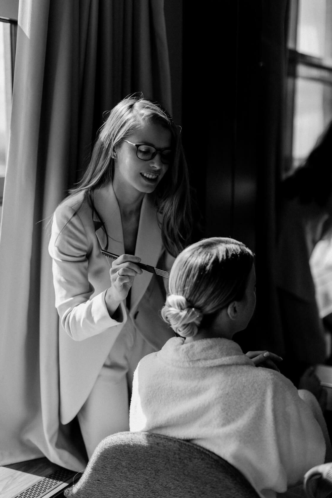 Свадебный стилист делает прическу