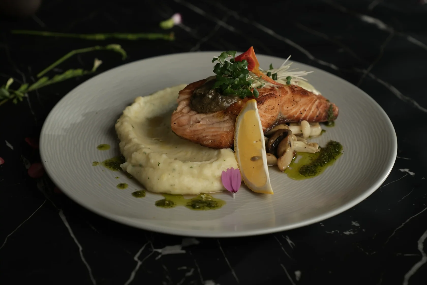 Pan-fried salmon with mashed potato, mushrooms, Alfredo sauce, and lemon