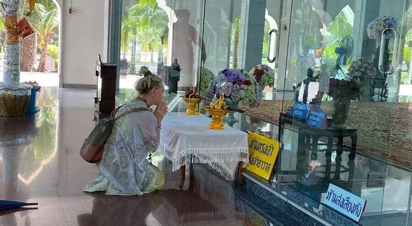 Туристка молится у алтаря в храме
