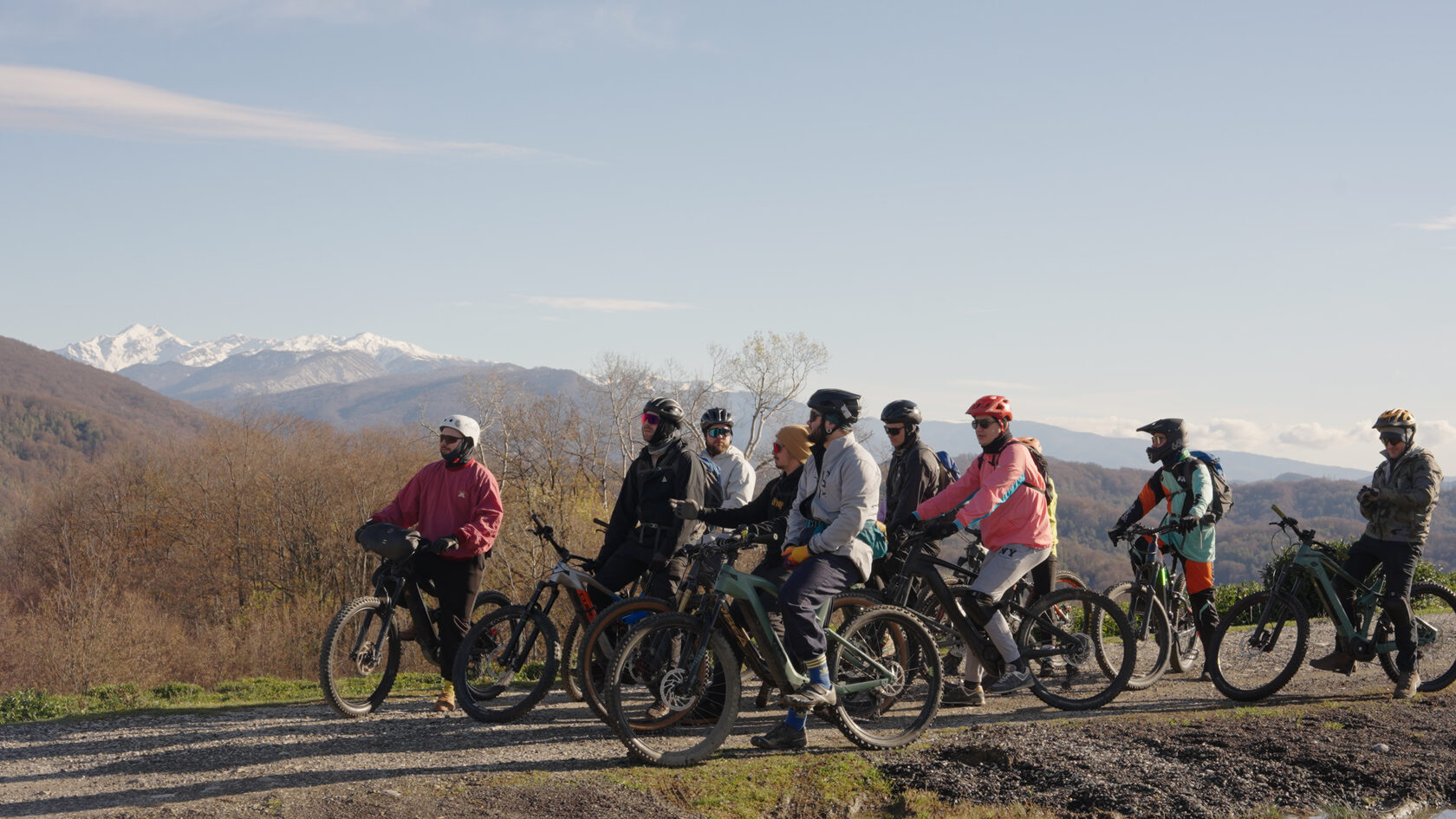 Группа взрослых райдеров с eMTB на фоне гор