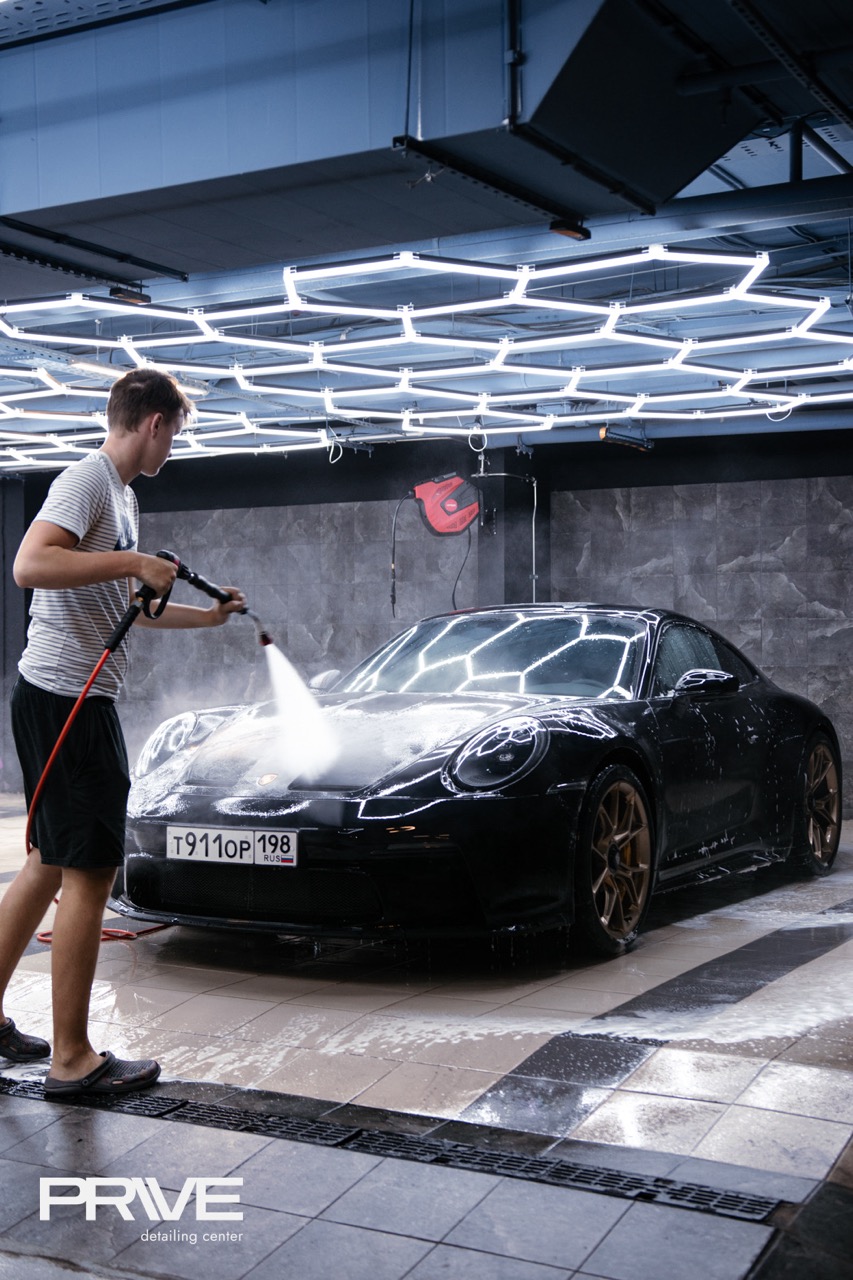 Мастер PRIVE моет Porsche в светлом детейлинг-боксе