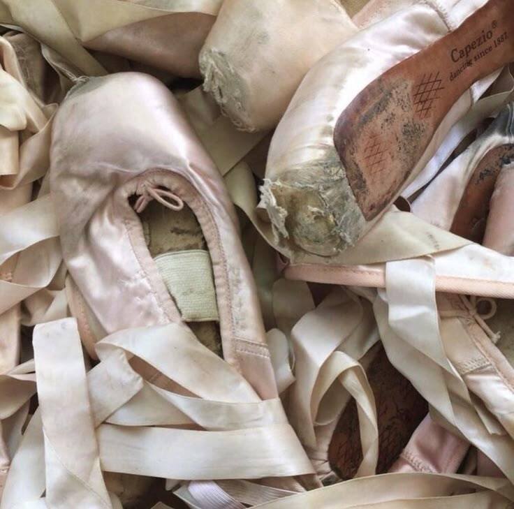 Изношенные пуанты и цветы за кулисами театра.