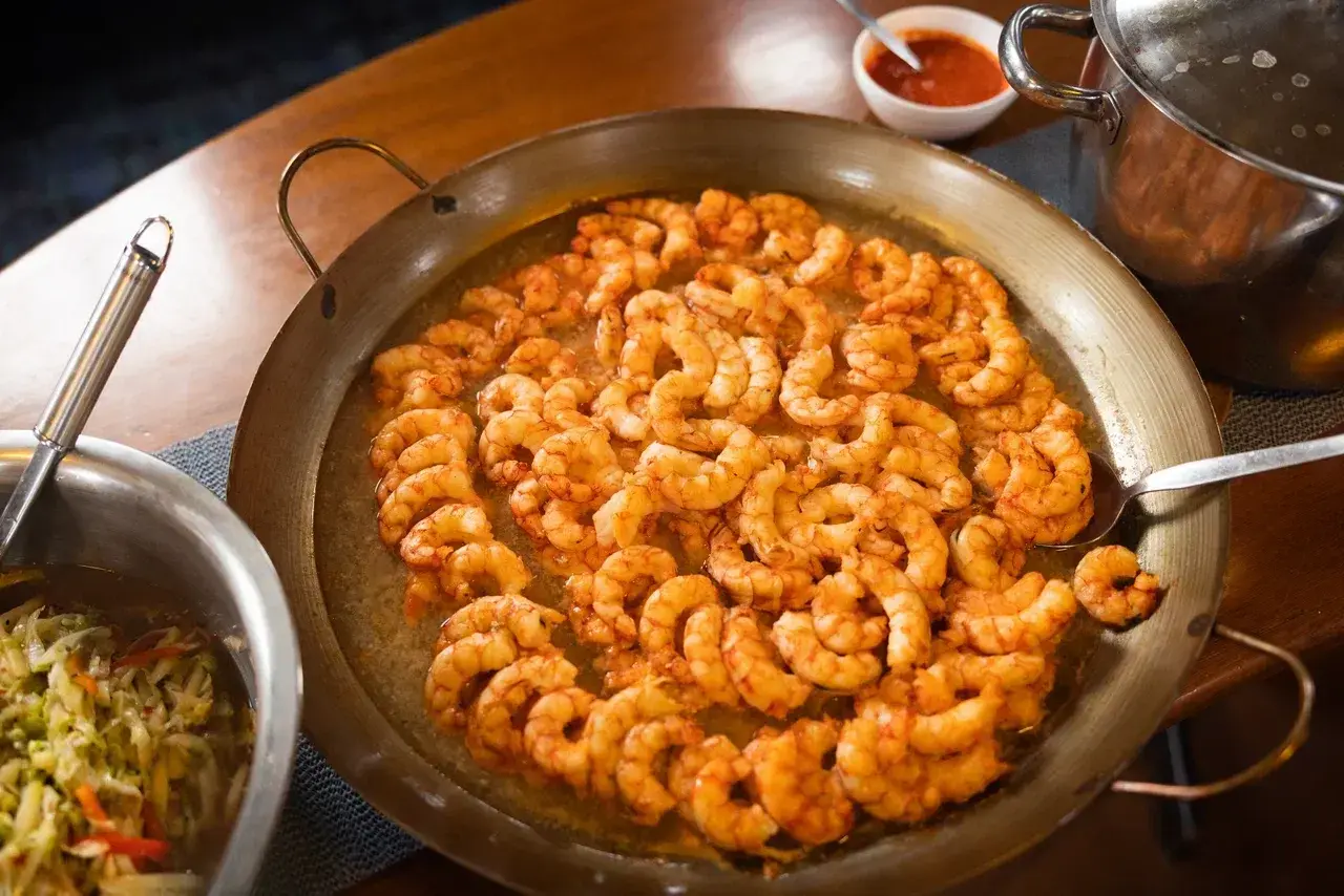 Freshly prepared shrimp served aboard a sailing yacht during a polar expedition. Warm, hearty meals are an important part of life at sea, bringing guests and crew together after days spent sailing, exploring remote coastlines and experiencing the Arctic or Antarctica.