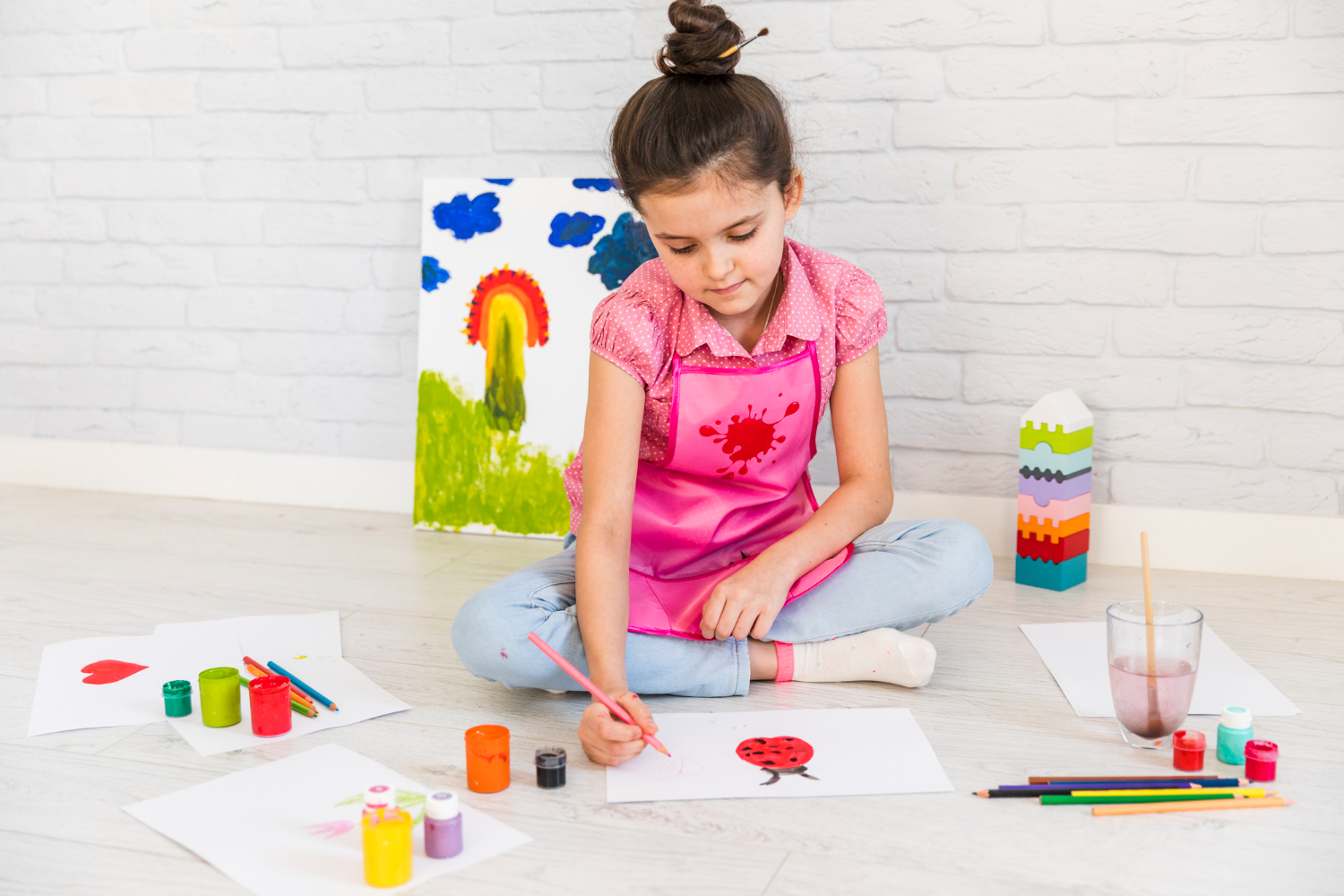 Kids painting. Девочка художница у интерактивной доски с песком рисует снеговика.