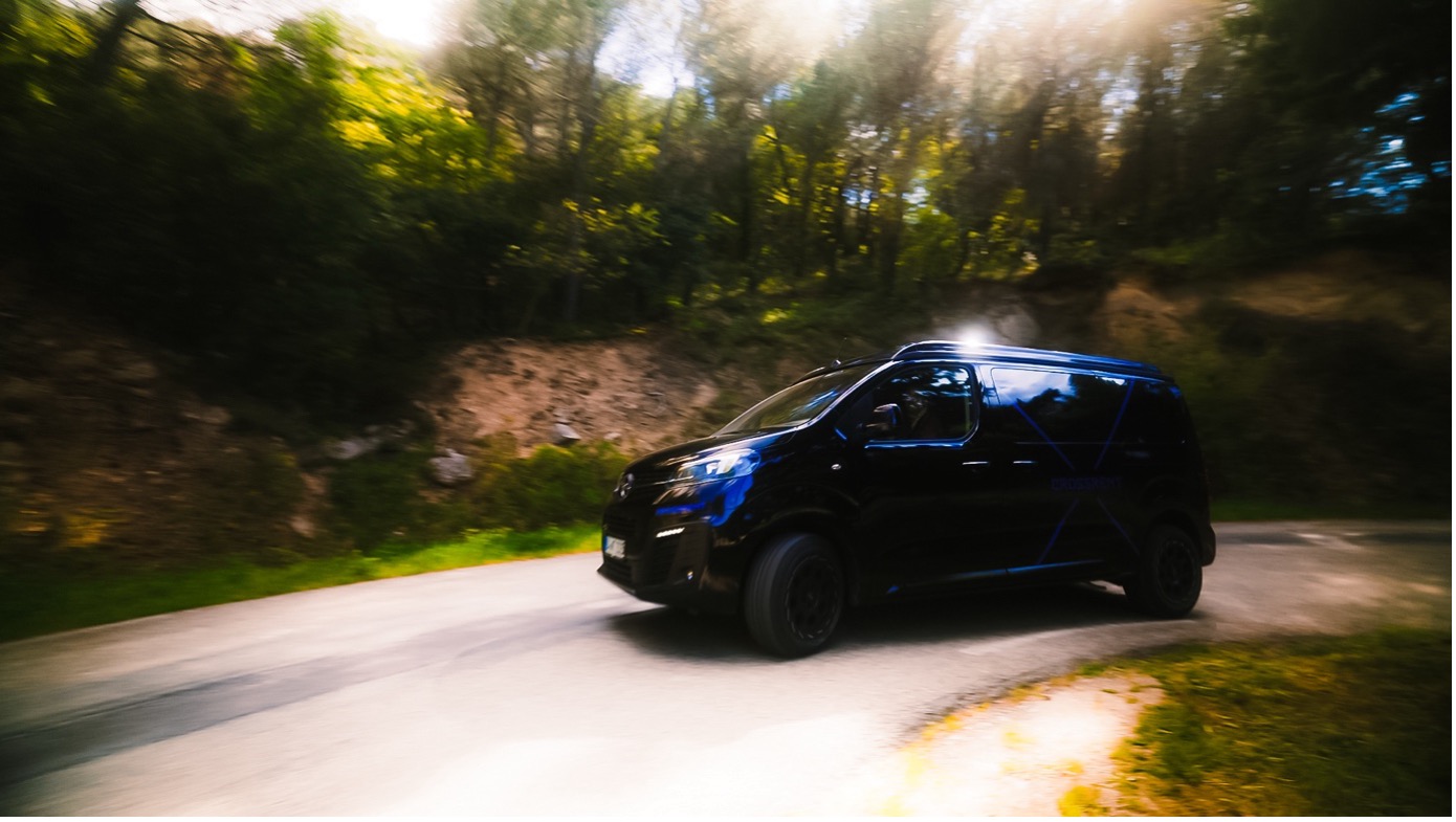 A black van driving on a road
AI-generated content may be incorrect.