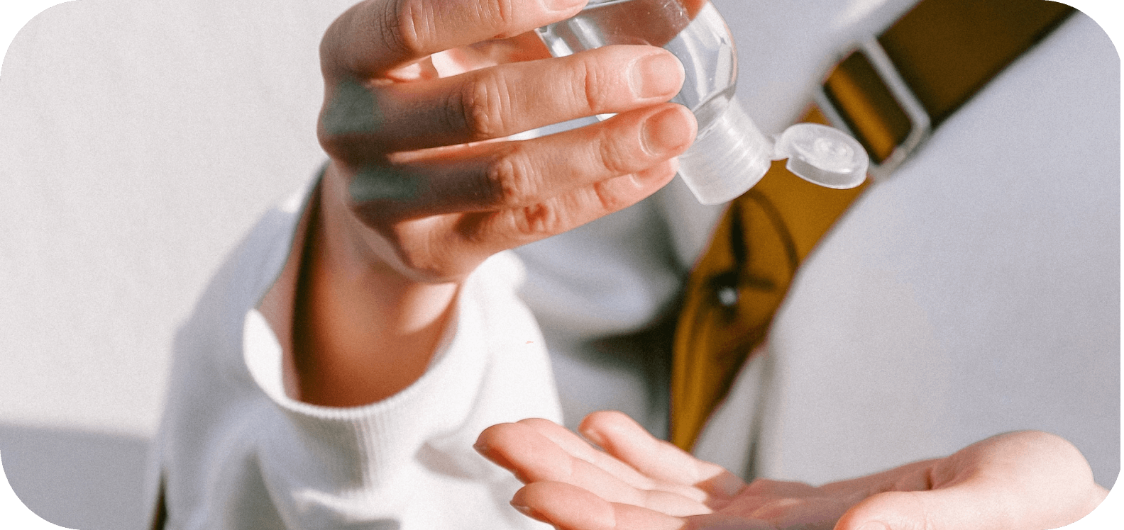 Человек наливает антисептическое средство на свою ладонь