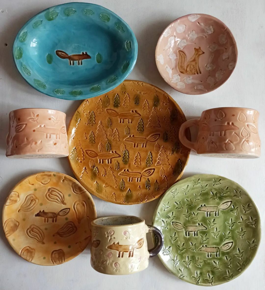 керамические тарелки и кружки разных цветов