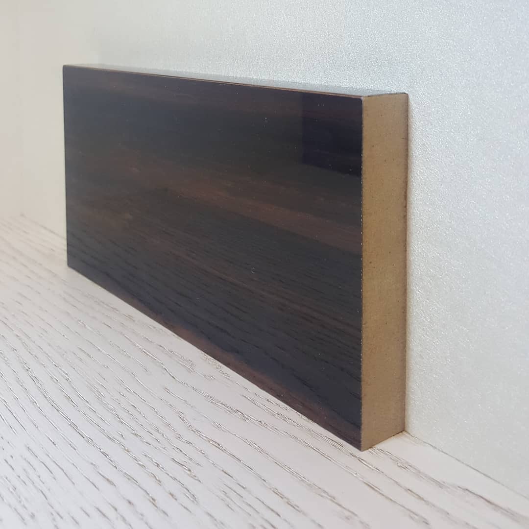 Современный плинтус в шпоне с гладкой отделкой, подчеркивающий контуры пола.