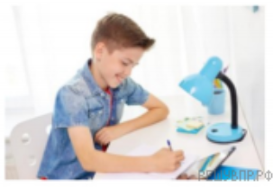 Мальчик пишет за столом