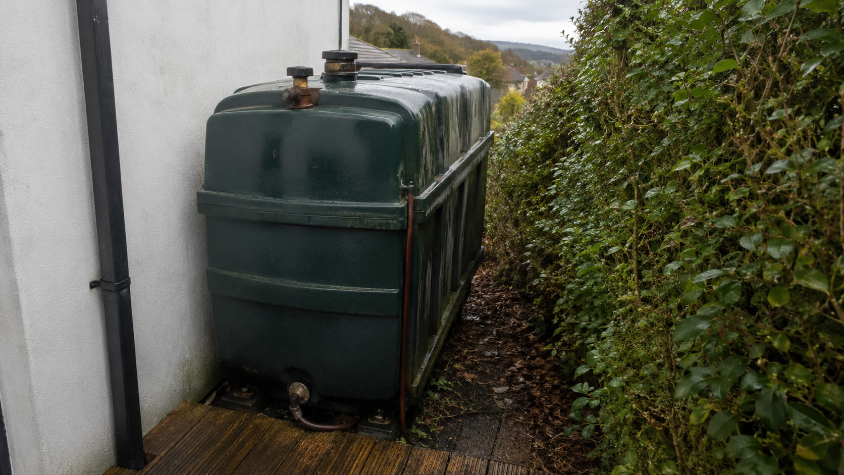 Old domestic oil tank in a tight garden space before replacement
