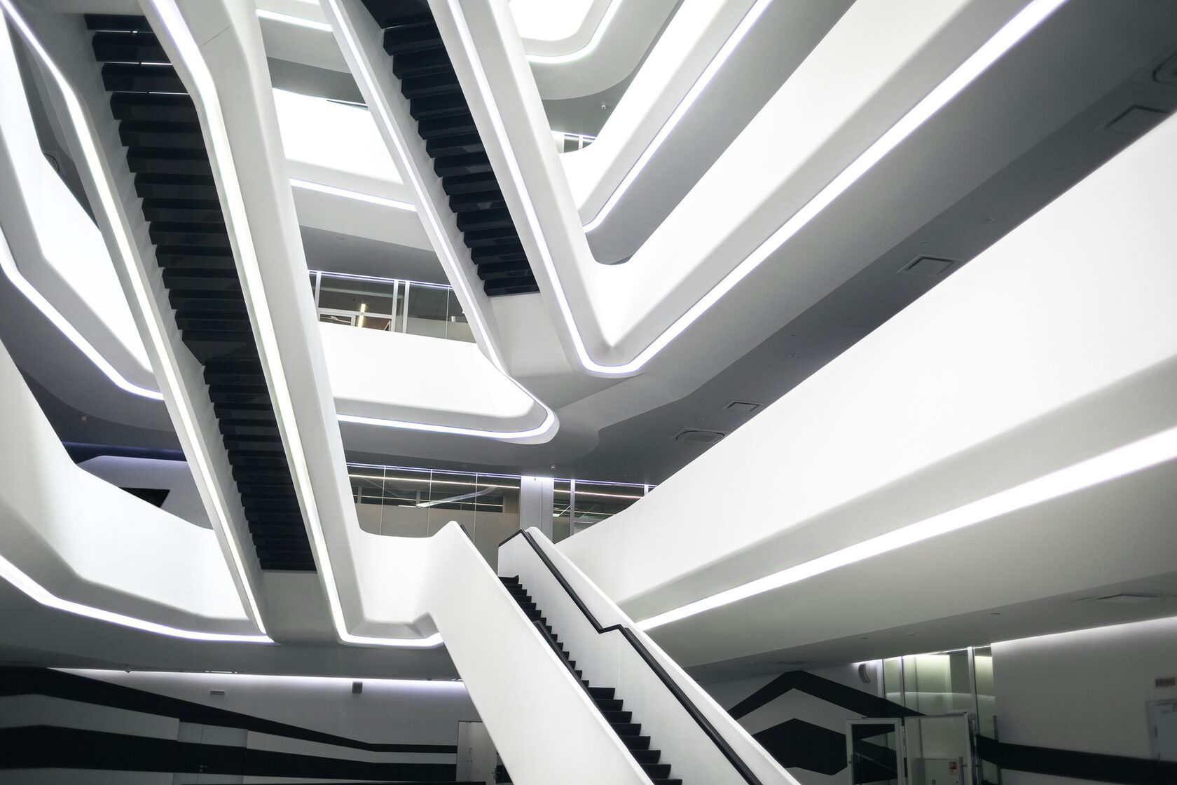 Modern futuristic building interior with white curved staircases and LED lighting