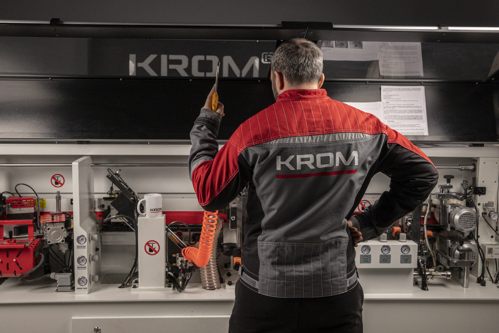 Специалист KROM выполняет настройку кромкооблицовочного станка