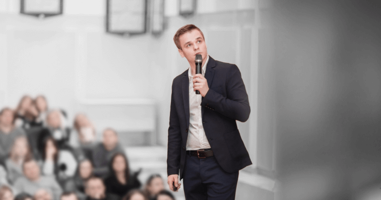 парень с микрофоном в руках выступает