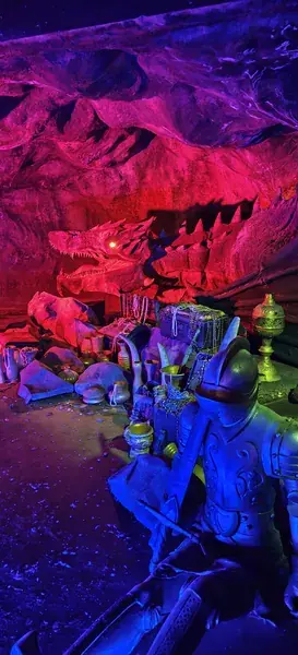 Рыцарь в доспехах и подсвеченный дракон в тёмном аттракционе парка Dream World