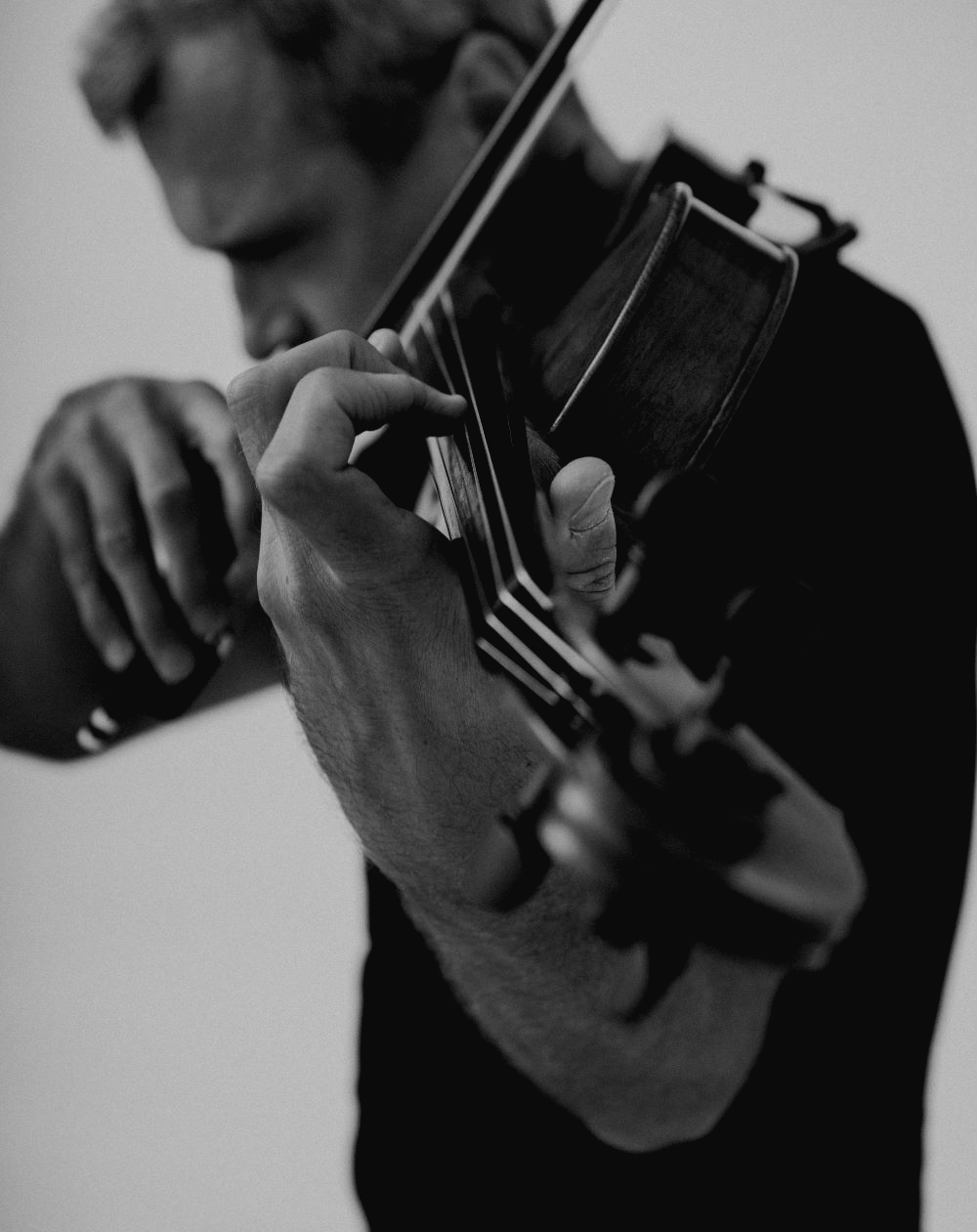 Черное-белое изображение мужчины, демонстрирующего игру на скрипке