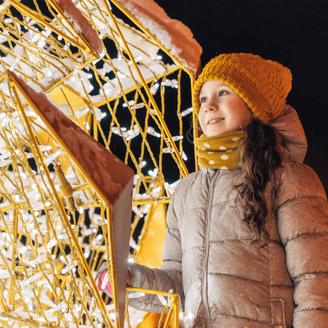 Девочка смотрит на световое украшение