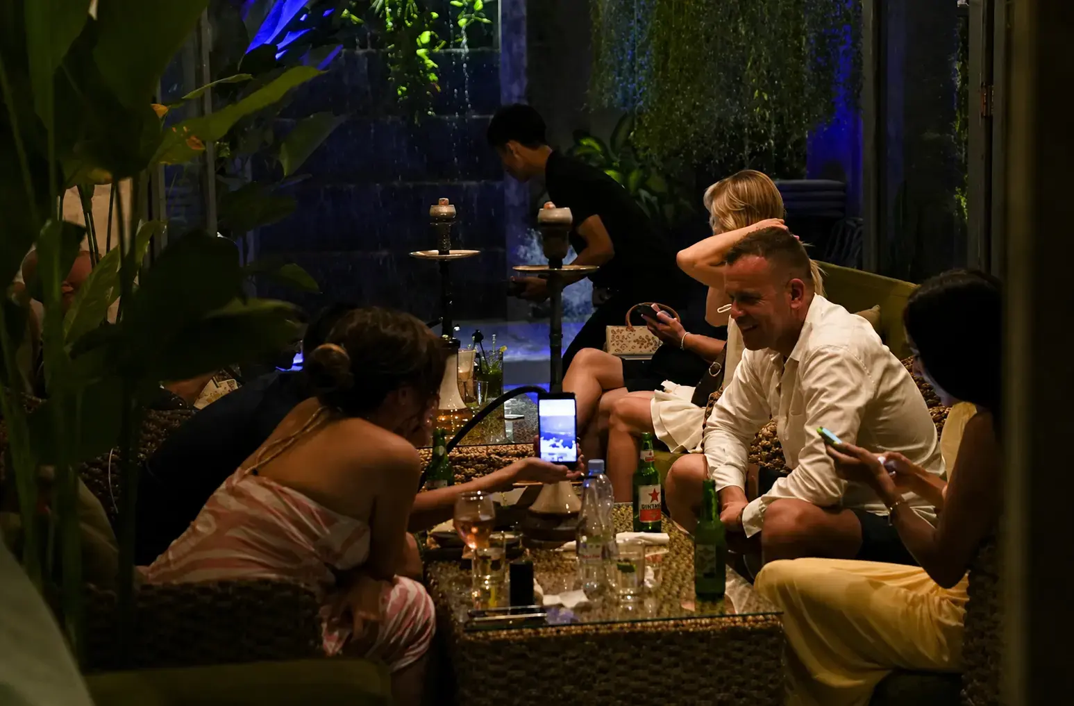 Guests enjoying premium shisha and drinks in a lush indoor setting at Eden Hookah Club Seminyak, a great spot for those wondering what happens in Bali on Wednesday.