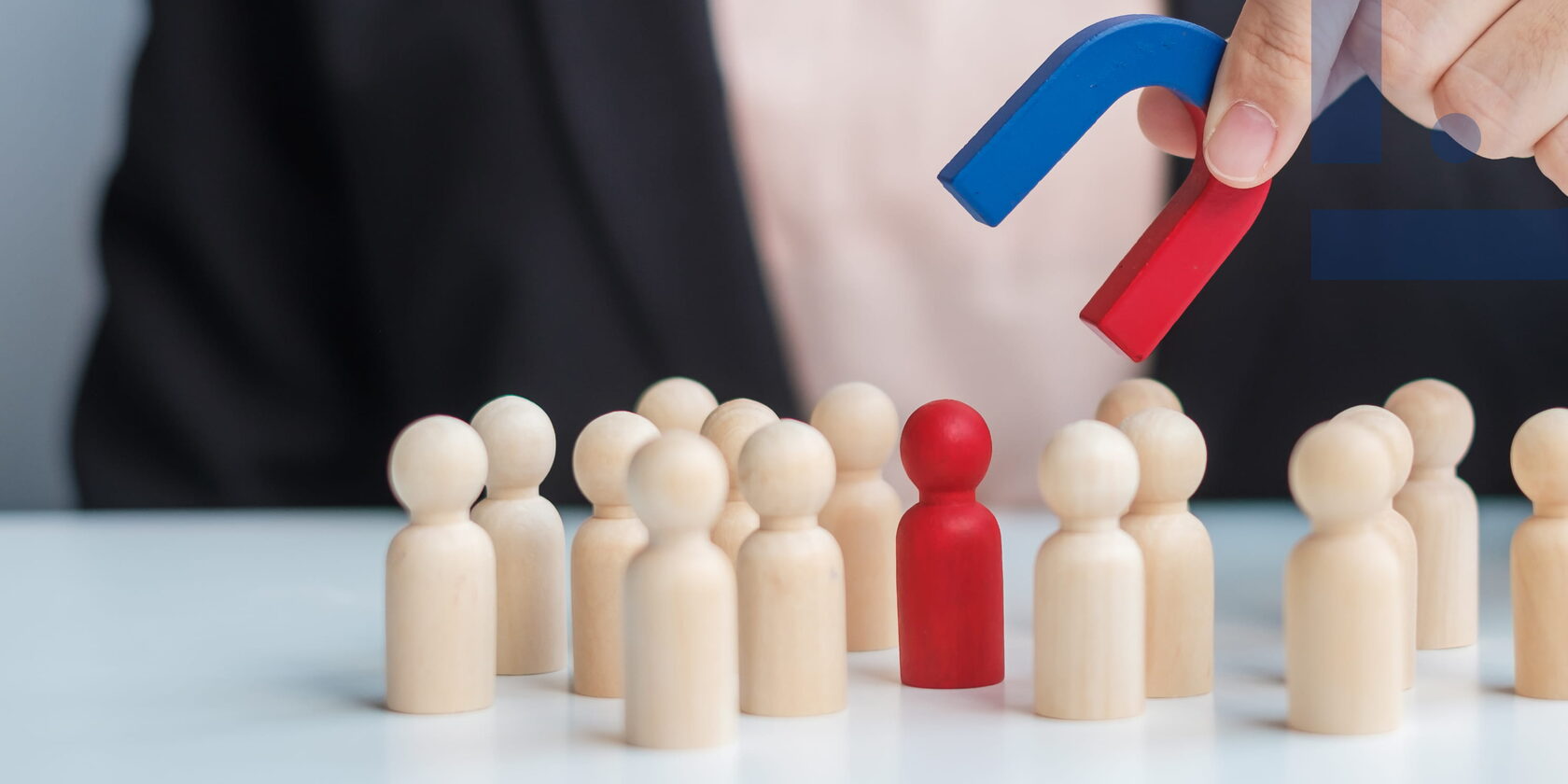 Manager and leader in people management: a magnet attracting an employee figure as a symbol of leadership, team motivation and managerial influence.