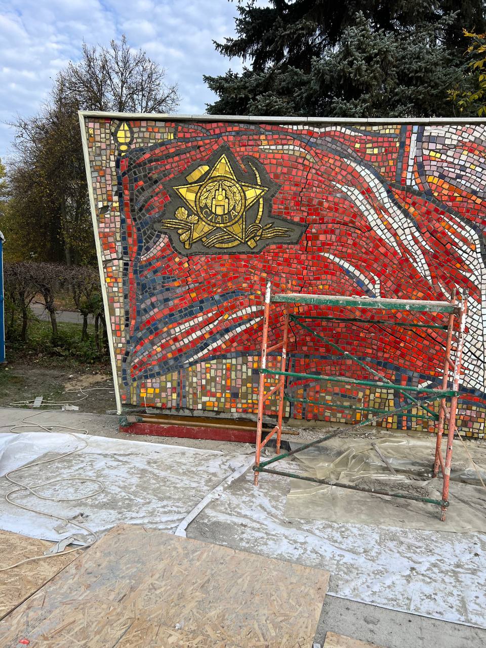 Смонтированное мозаичное панно на изогнутом основании мемориала в лесах