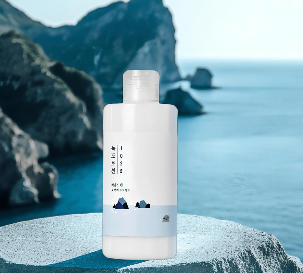 Флакон лосьона Round Lab 1025 Dokdo Lotion с дозатором на фоне морского пейзажа