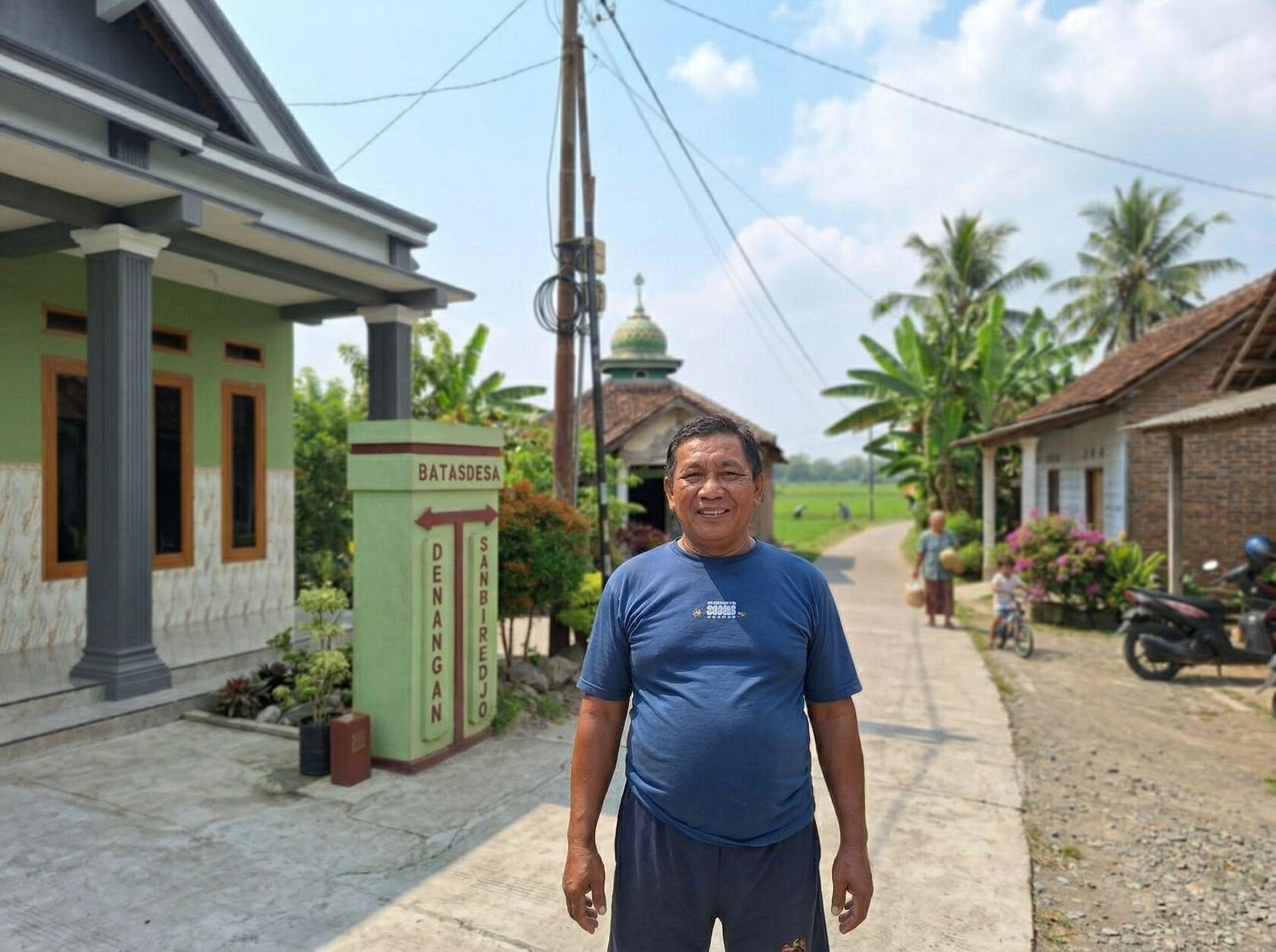 Warga desa Indonesia di depan rumah dekat batas desa Nganjuk