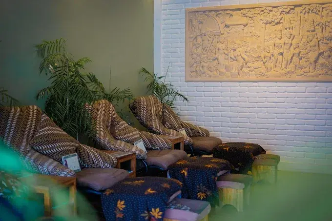 A row of comfortable reclining chairs dressed with traditional batik blankets at NUSA THERAPY, offering a highly reliable and authentic best spa in Ubud experience.