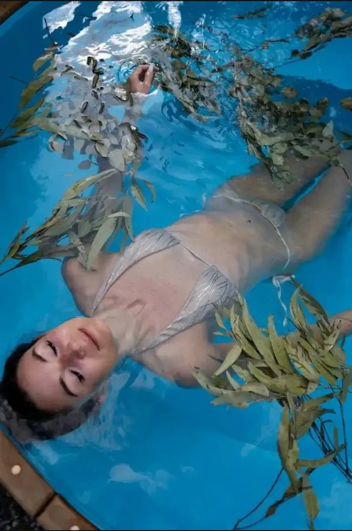 Женщина спокойно лежит в воде, вид сверху