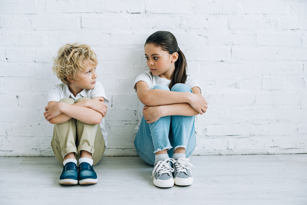 Sister sitting. Брат и сестра стоковые. Сестра и брат сидят вместе на полу. Брат с сестрой на голубом фоне позируют в обуви. Младшая сестра сидит на полу.