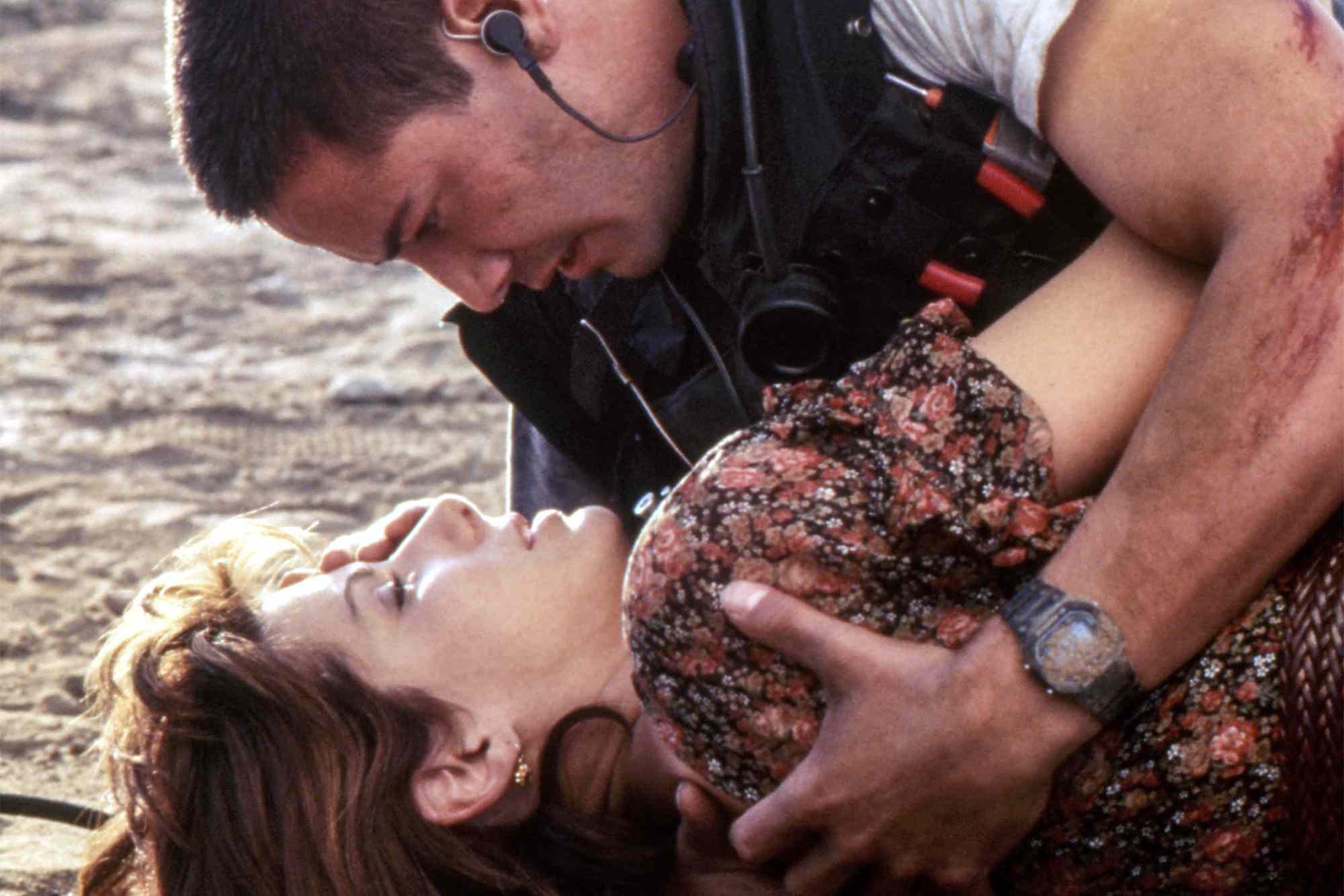 Speed: Jack and Annie lie on the ground, Jack on top of her. Both are dirty and exhausted from escaping yet another terrorist bombing.