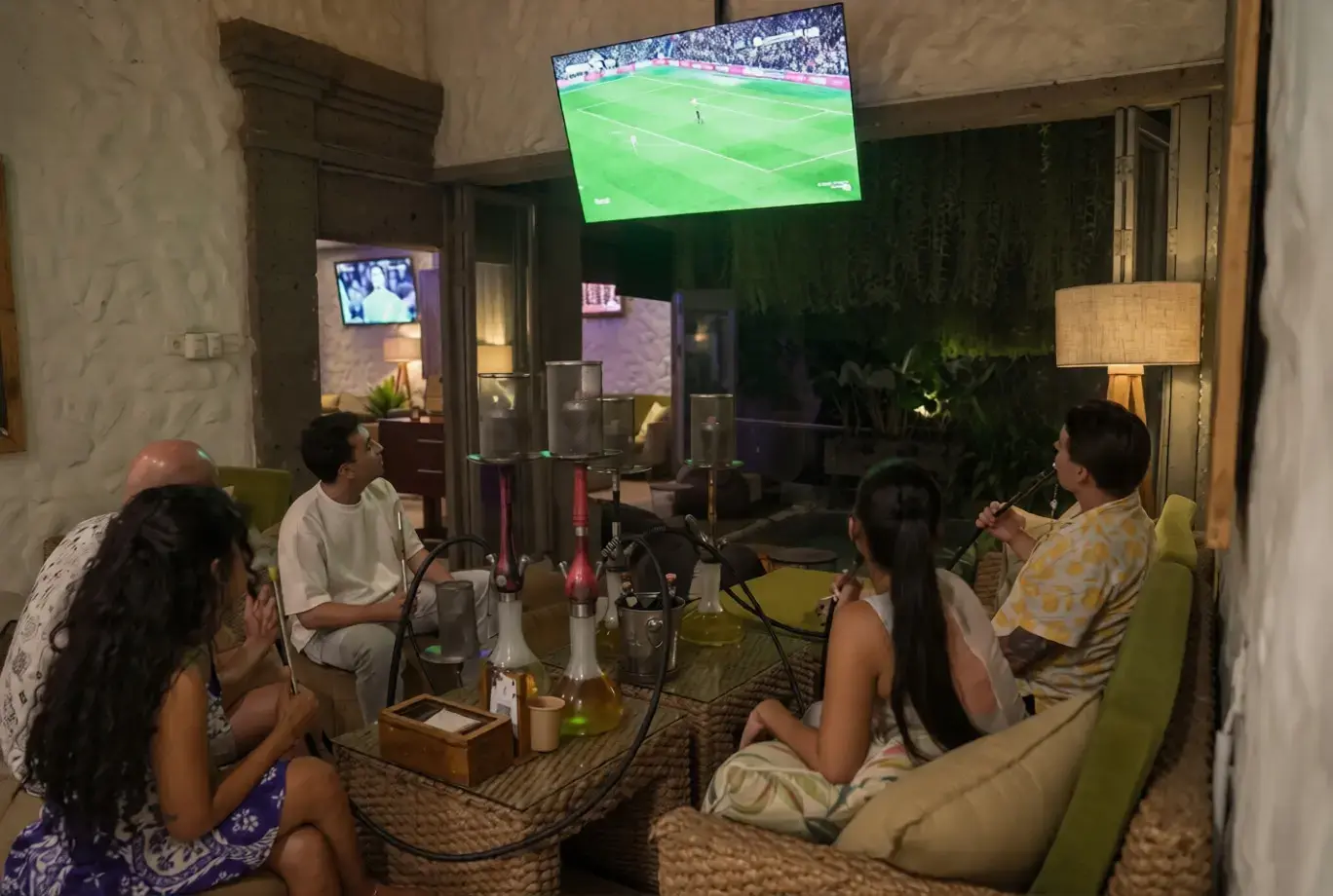 Friends enjoying premium shisha sessions together while watching a live football broadcast, representing the best places to watch FIFA World Cup 2026 in Bali.
