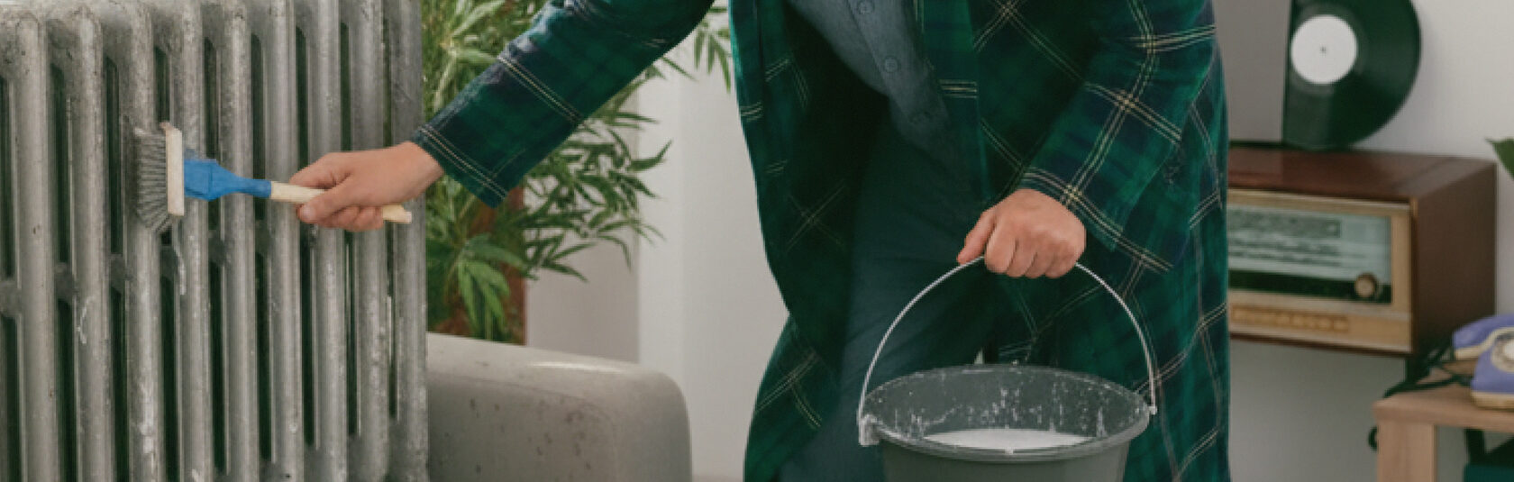 Мытьё батарей в квартире: ручная уборка радиатора с водой и щёткой.