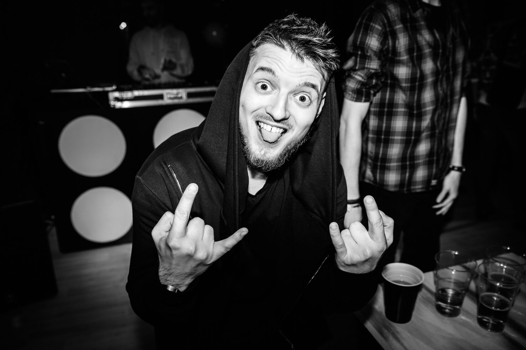 Эмоциональный чёрно-белый портрет DJ ROZHKOV среди гостей на вечеринке.
