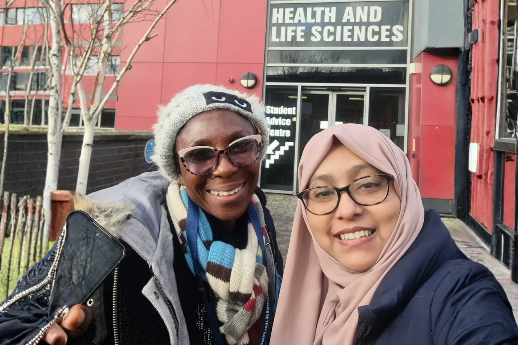 Student Consultant Afsana (left) with her student client (right) in front of De Montfort University's Health & Life Science building