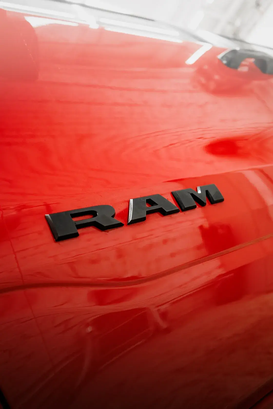 Чёрный шильдик RAM на красном кузове